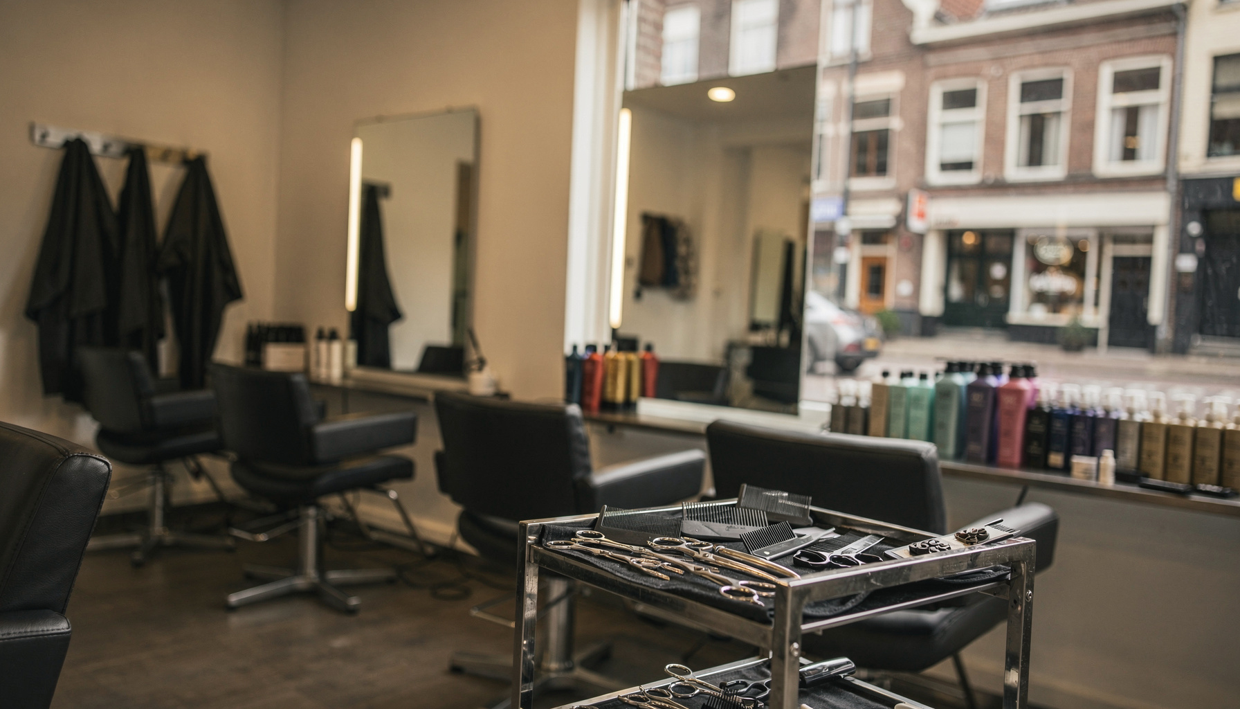 Lege kapsalon in ochtendlicht met stoelen, spiegels en gereedschap klaar voor de dag