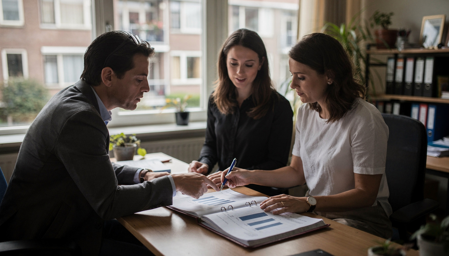 Twee collega's in een vastgoedkantoor vergelijken een kosten-batenoverzicht met een onderhoudslogboek.