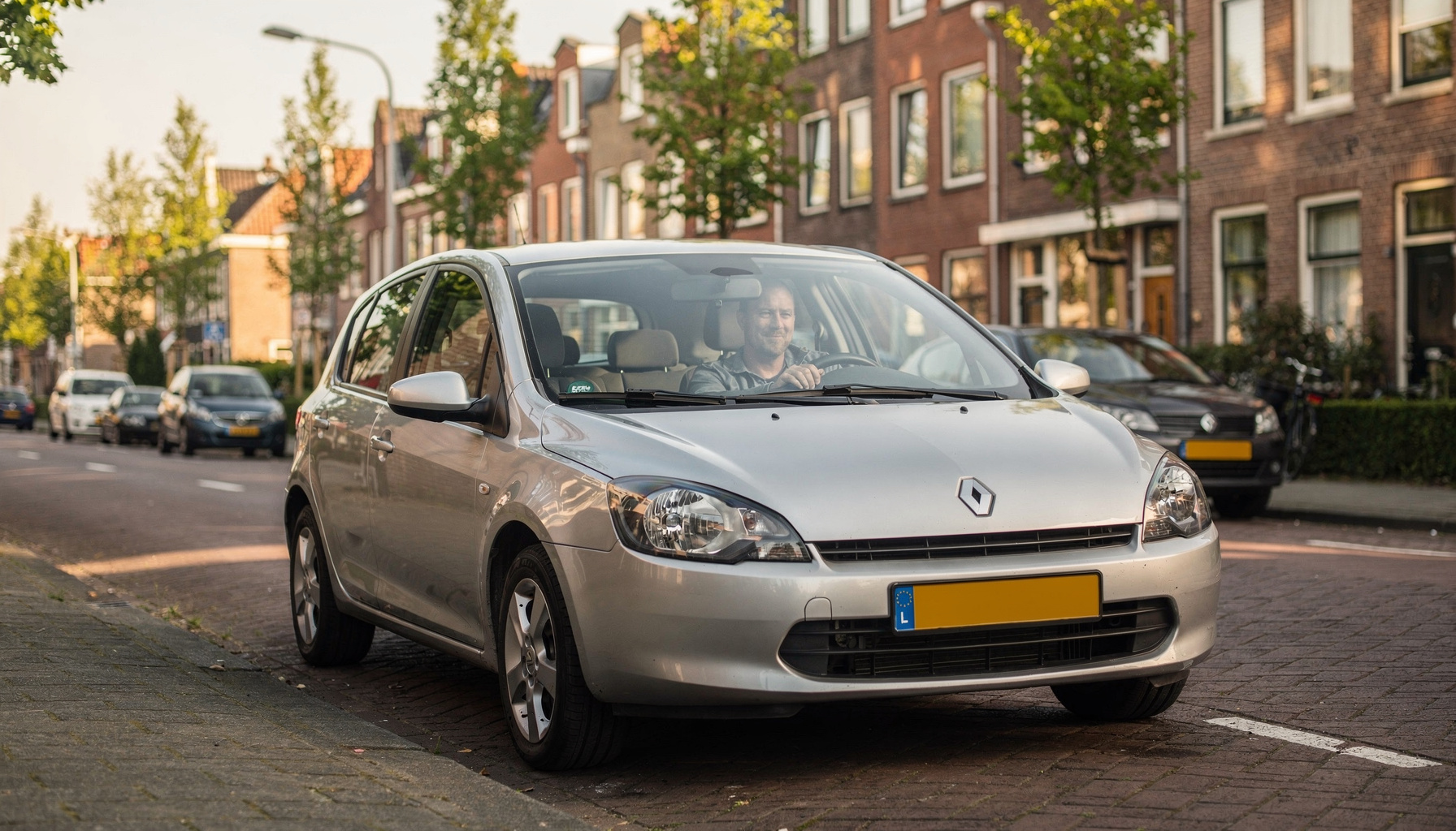 Een man rijdt in zijn nieuwe hatchback door een rustige Nederlandse woonstraat in het ochtendlicht.